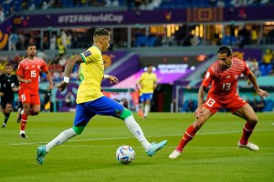 Brazilian attacker Raphinha dribbles at Swiss defender during World Cup match up