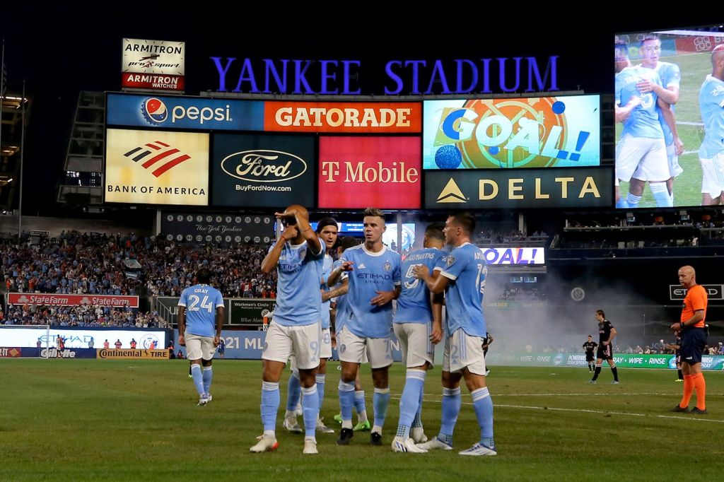 NYCFC players celebrate scoring a goal while playing in Yankees Stadium