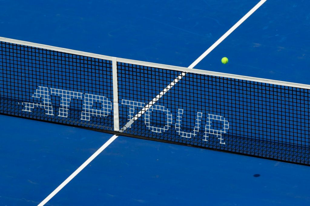 Tennis ball moving over net branded with ATP Tour logo