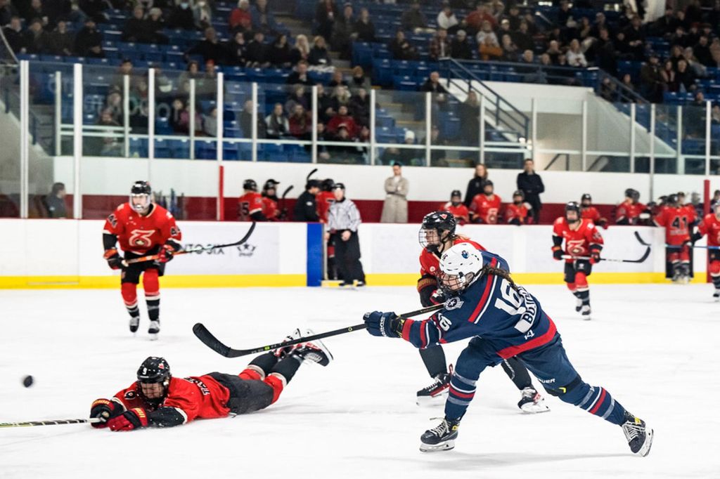 Woman attempts shot during Premiere Hockey Federation matchup