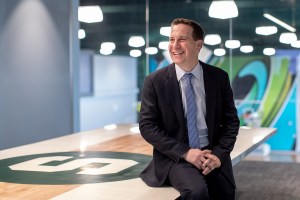 New Phoenix Suns owner Mat Ishbia smiles while leaning on table