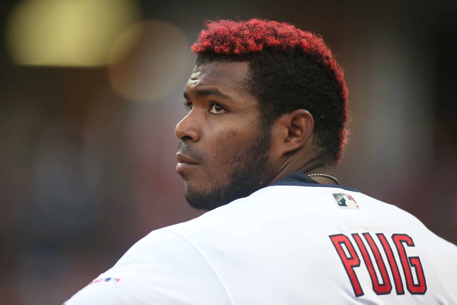 Baseball player Yasiel Puig looks over shoulder in dug-out