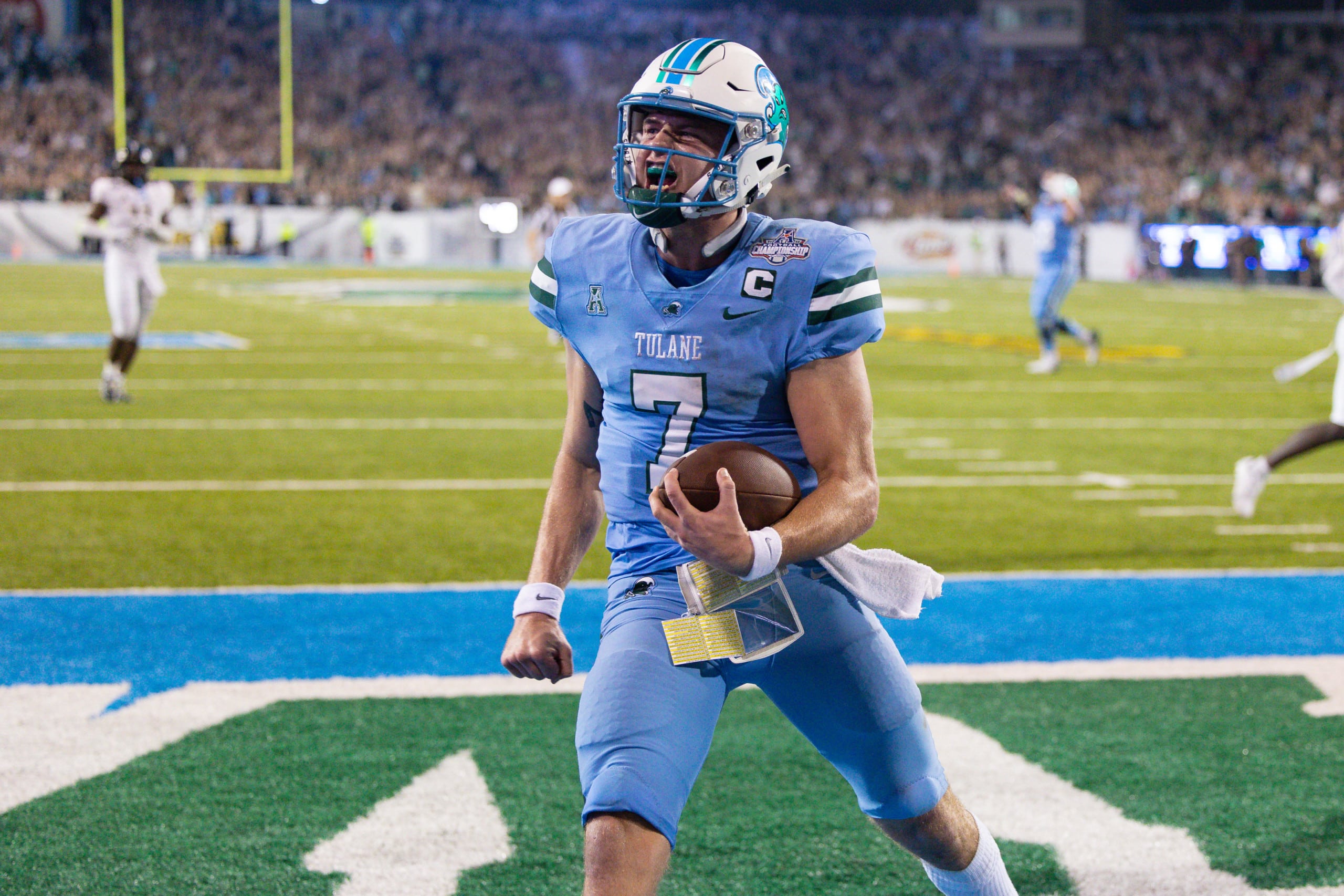 Tulane quarterback celebrates in the end zone after scoring a touchdown