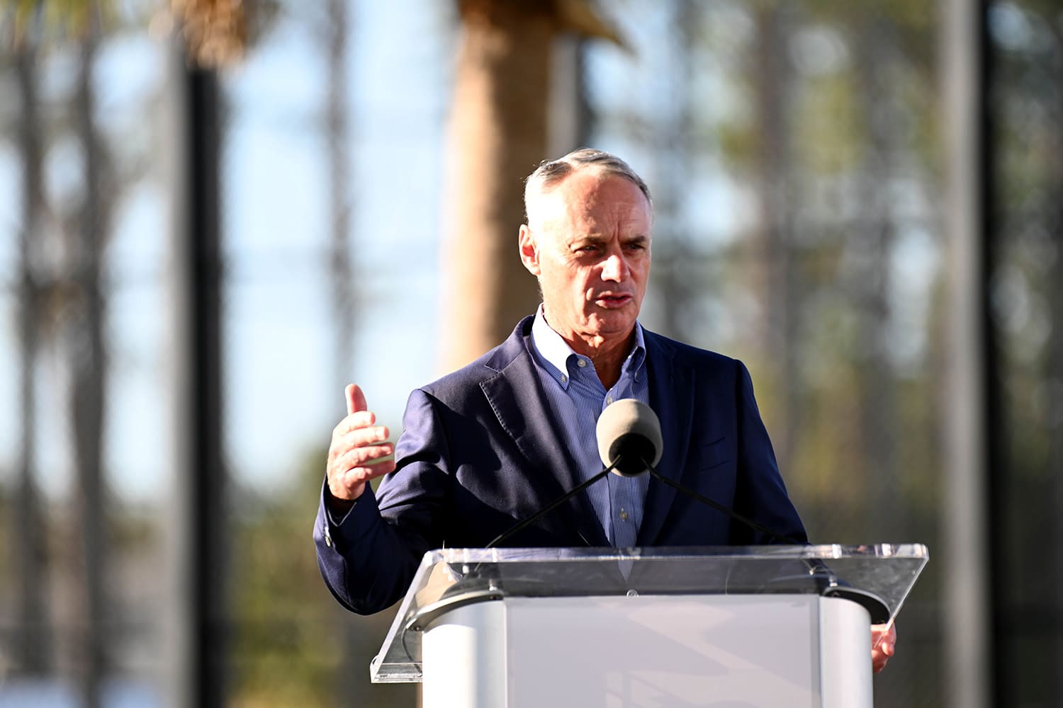 MLB Commissioner Rob Manfred addresses the media from a podium during spring training.