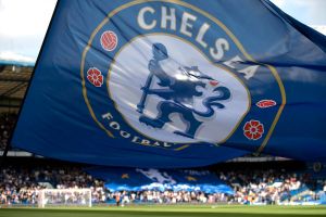 A Chelsea FC banner is waved over the field at Stamford Bridge stadium.