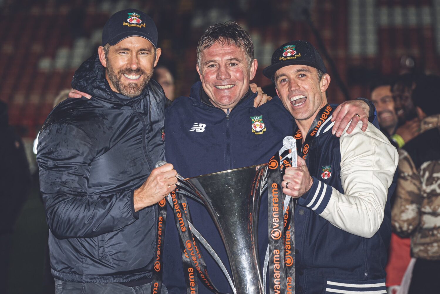 Wrexham's Ryan Reynolds, Phil Parkinson, and Rob McElhenney pose with the National League trophy.