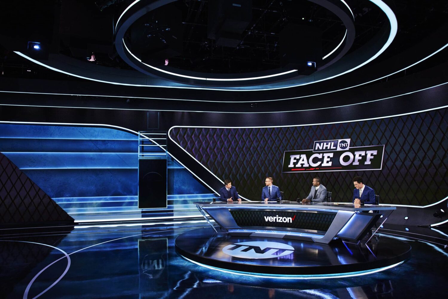 A wide angle view of the "NHL on TNT" studio desk with Wayne Gretzky, Liam McHugh, Anson Carter, and Paul Bissonnette.