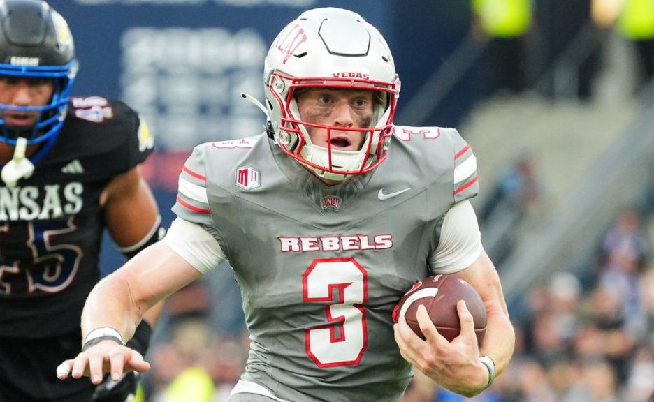 Sep 13, 2024; Kansas City, Kansas, USA; UNLV Rebels quarterback Matthew Sluka (3) runs the ball against Kansas Jayhawks defensive end Dean Miller (45) and cornerback Cobee Bryant (2) during the first half at Children's Mercy Park.