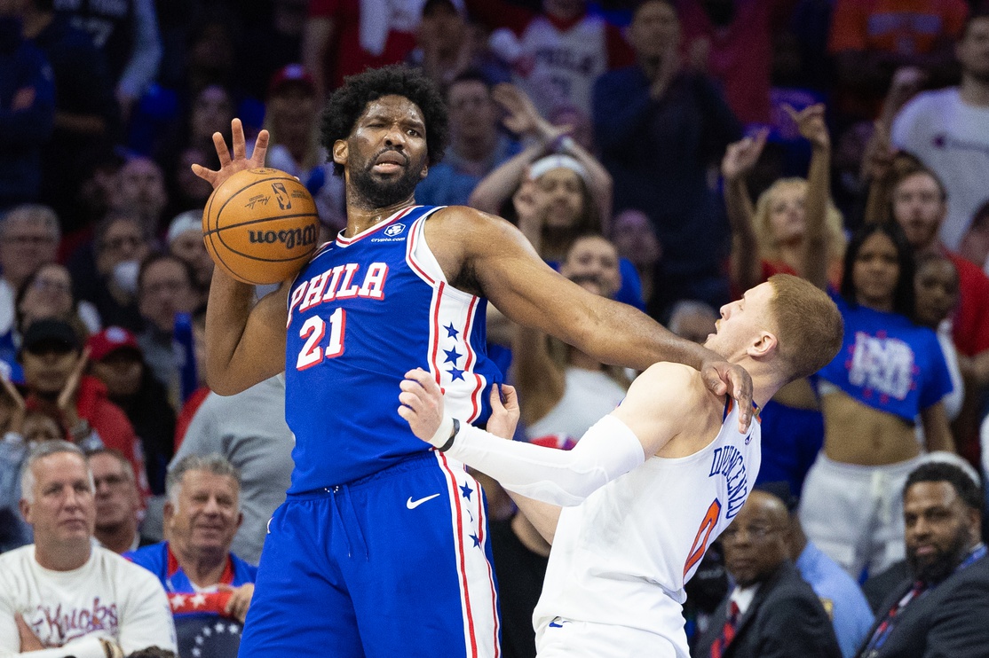 Apr 25, 2024; Philadelphia, Pennsylvania, USA; Philadelphia 76ers center Joel Embiid (21) is fouled by New York Knicks guard Donte DiVincenzo (0) during the second half of game three of the first round for the 2024 NBA playoffs at Wells Fargo Center.