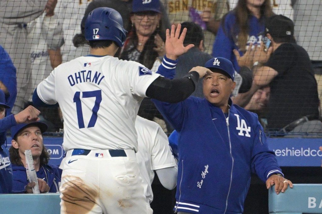 Sep 26, 2024; Los Angeles, California, USA;Los Angeles Dodgers designated hitter Shohei Ohtani (17) is greeted by manager Dave Roberts (30) after scoring on a RBI single by shortstop Mookie Betts (50) in the seventh inning against the San Diego Padres at Dodger Stadium.