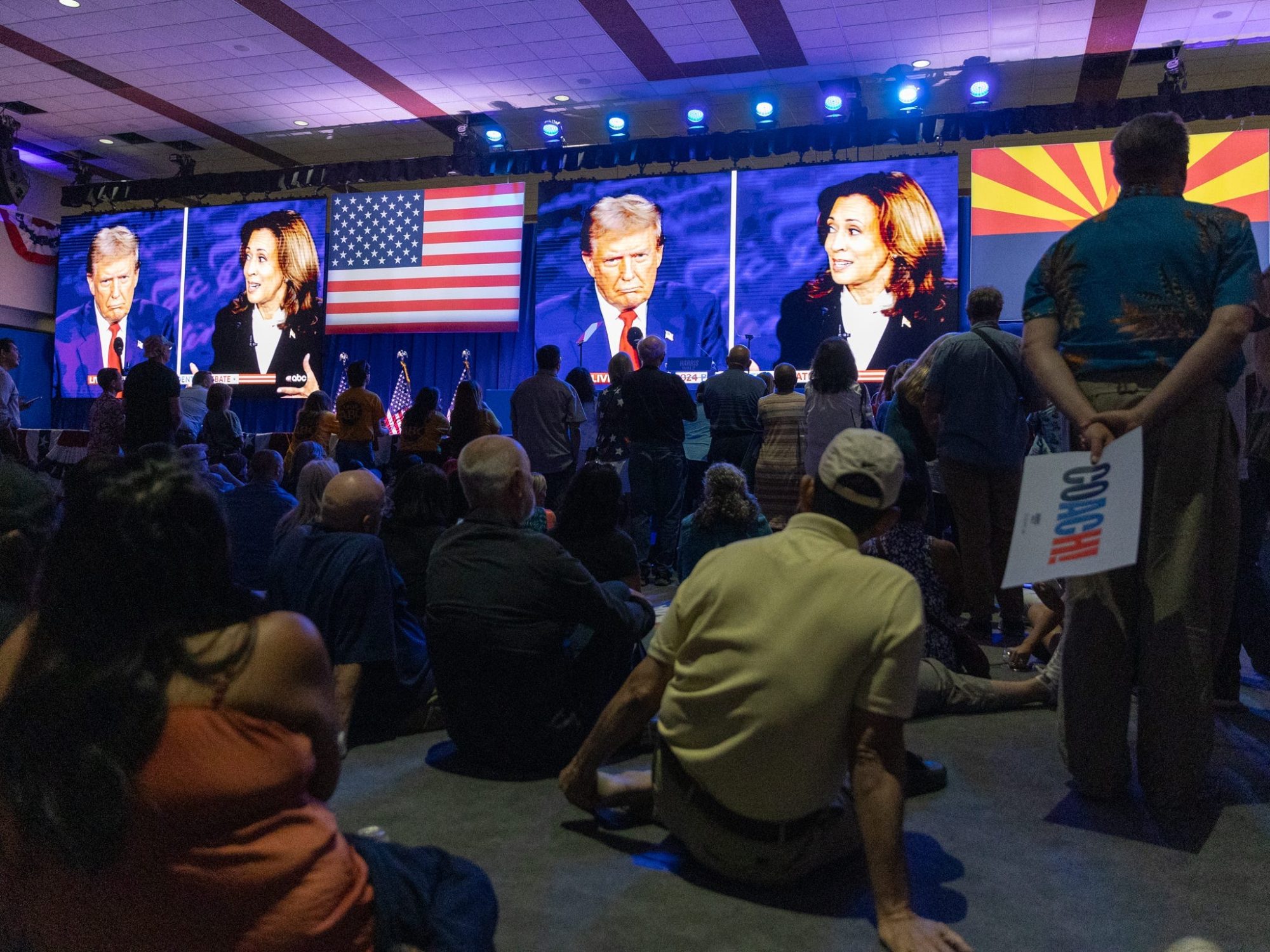 People at the Mesa Convention Center watch former President Donald J. Trump and Vice President Kamala Harris debate on Sept. 10, 2024.