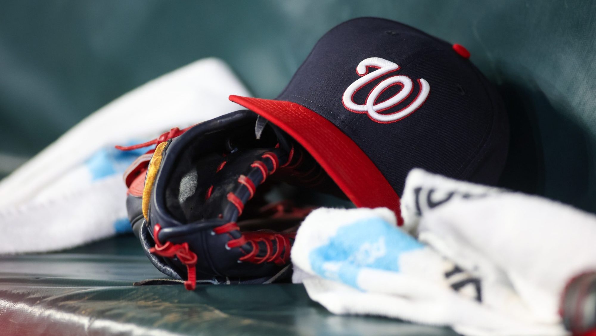 May 30, 2024; Atlanta, Georgia, USA; A detailed view of a Washington Nationals hat and glove on the bench against the Atlanta Braves in the ninth inning at Truist Park.