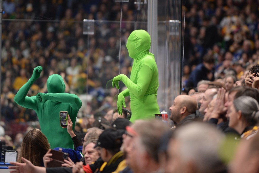 Feb 24, 2024; Vancouver, British Columbia, CAN;  The green men make an appearanc near the Boston Bruins penalty bench during the first period agaisnt the Vancouver Canucks at Rogers Arena. 