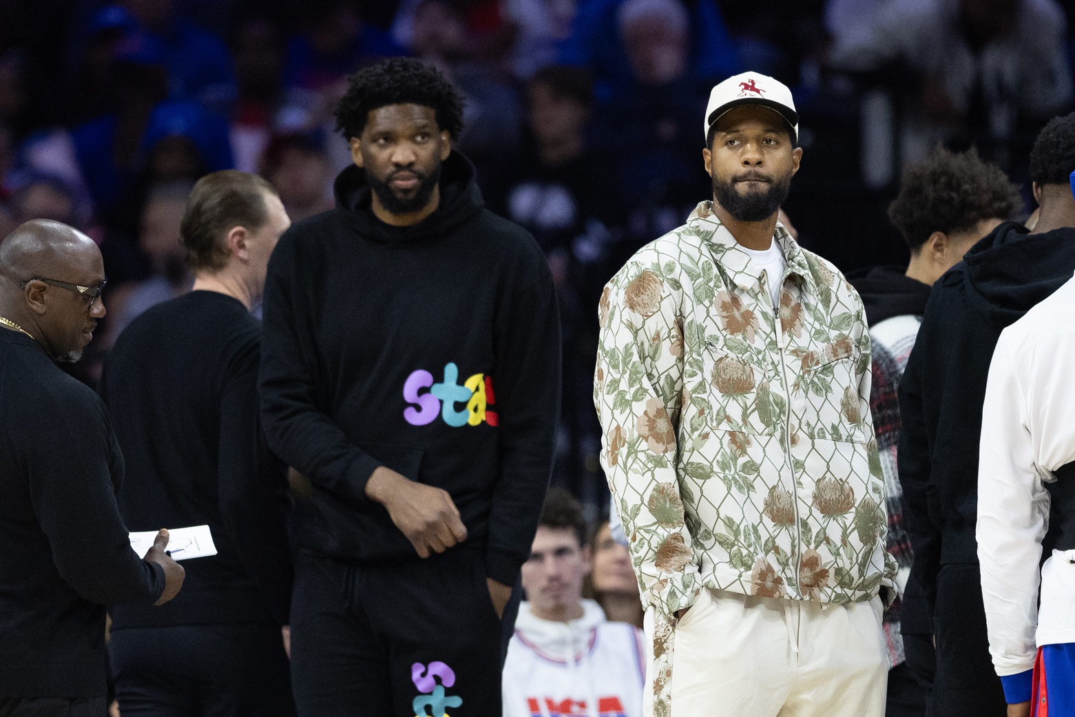 Nov 2, 2024; Philadelphia, Pennsylvania, USA; Injured Philadelphia 76ers Paul George (R) and Joel Embiid (L) look on during the first quarter against the Memphis Grizzlies at Wells Fargo Center.