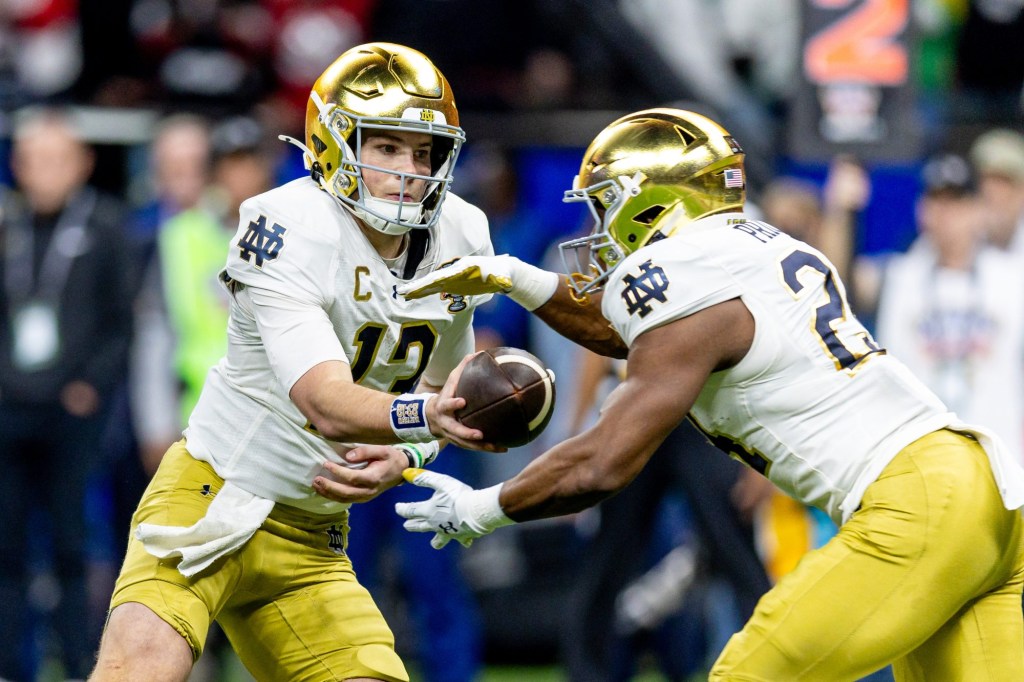 Jan 2, 2025; New Orleans, LA, USA;  Notre Dame Fighting Irish quarterback Riley Leonard (13) hands off to Notre Dame Fighting Irish running back Jadarian Price (24) on a run against the Georgia Bulldogs during the second half at Caesars Superdome.