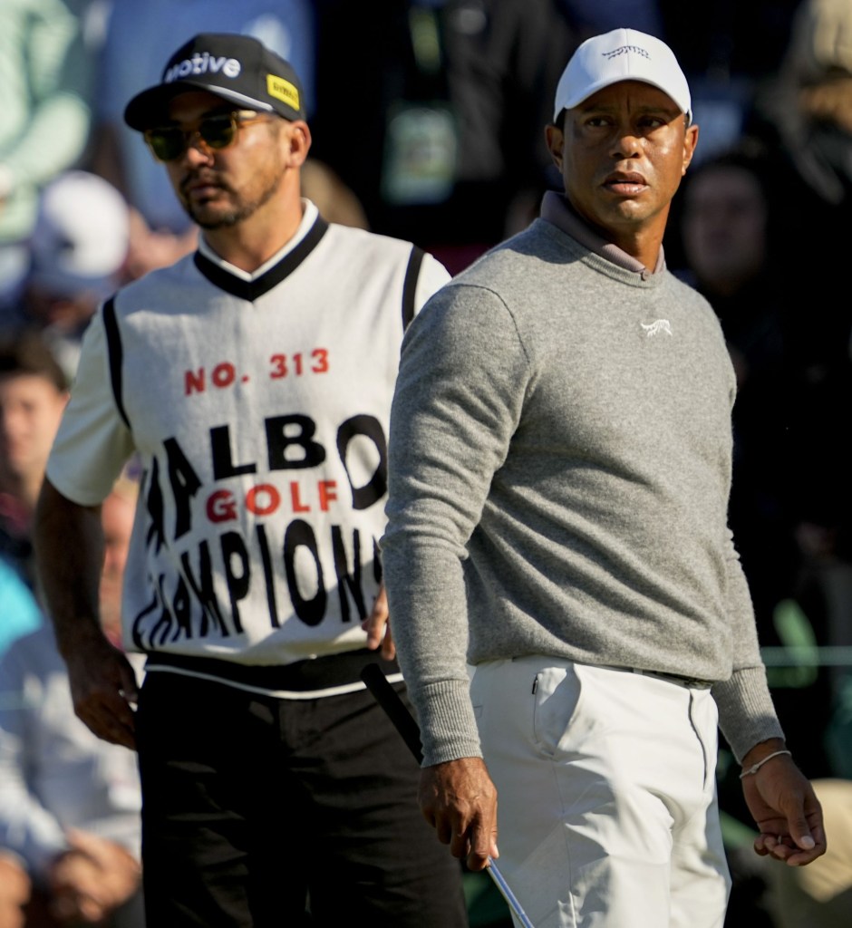 Apr 12, 2024; Augusta, Georgia, USA; Tiger Woods and Jason Day check the scoreboard after finishing on no. 18 during the completion of the first round of the Masters Tournament.