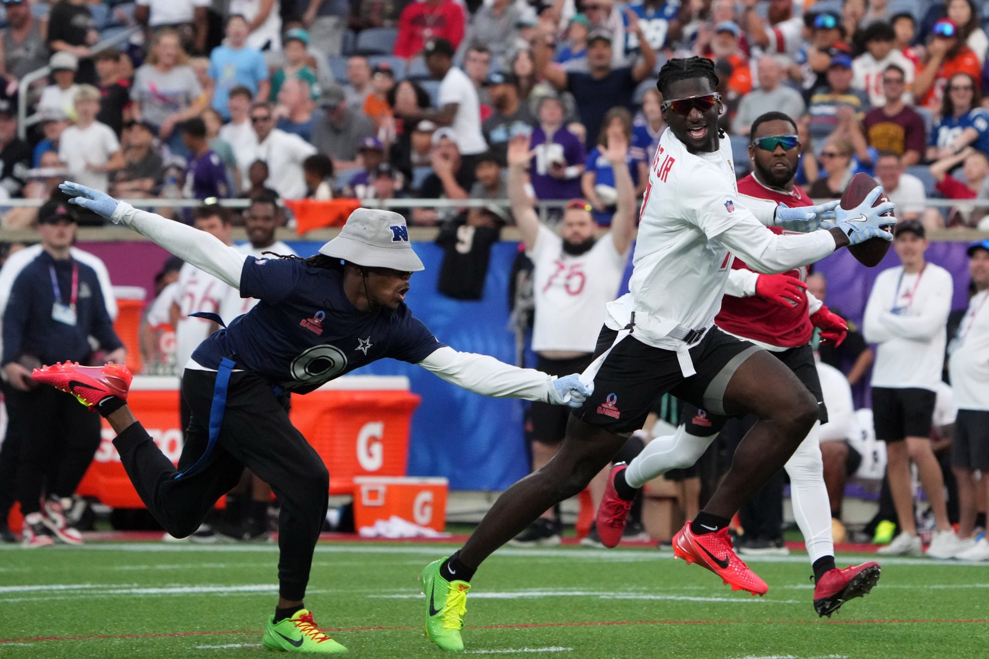 Feb 2, 2025; Orlando, FL, USA; AFC wide receiver Brian Thomas Jr. of the Jacksonville Jaguars (7) carries the ball against NFC return specialist KaVontae Turpin of the Dallas Cowboys (9) during the 2025 Pro Bowl Games at Camping World Stadium.