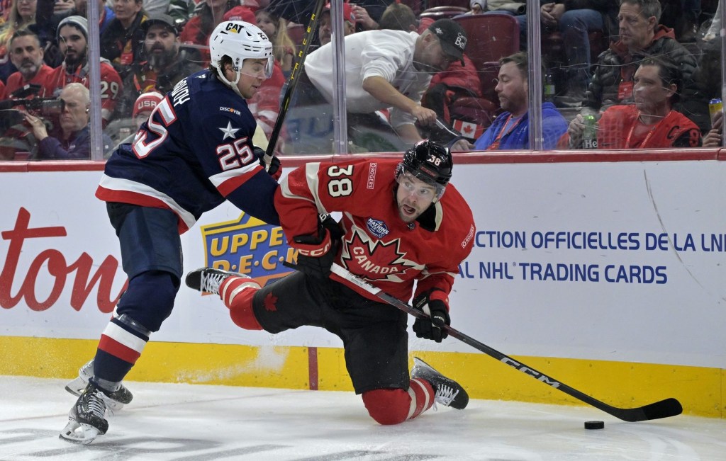 Feb 15, 2025; Montreal, Quebec, CAN; [Imagn Images direct customers only] Team Canada forward brandon Hagel (38) plays the puck and Team United States defenseman Charlie McAvoy (25) defends in the second period during a 4 Nations Face-Off ice hockey game at the Bell Centre