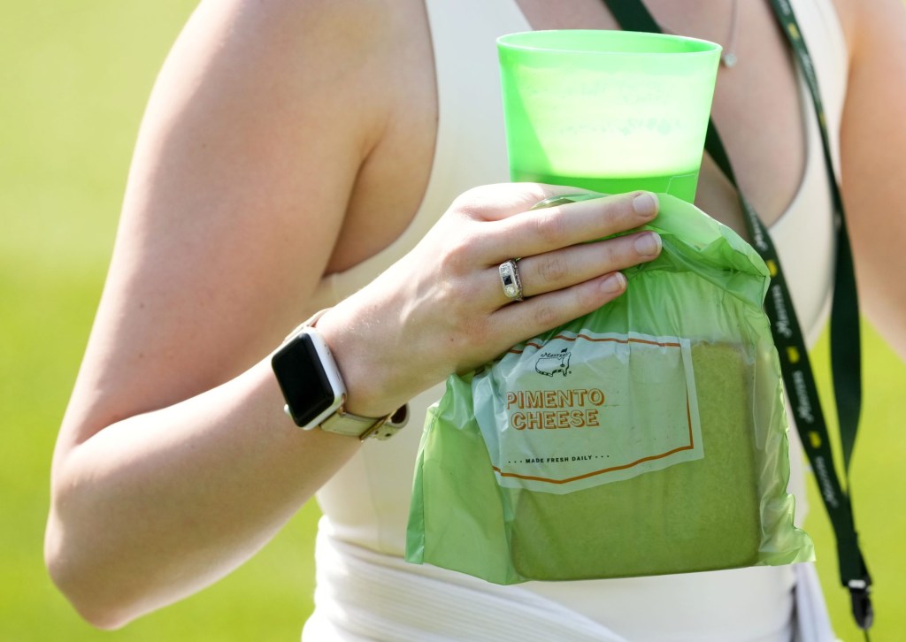 Apr 4, 2022; Augusta, Georgia, USA; A patron holds a pimento cheese sandwich along with a beverage during a practice round of The Masters golf tournament at Augusta National Golf Club.