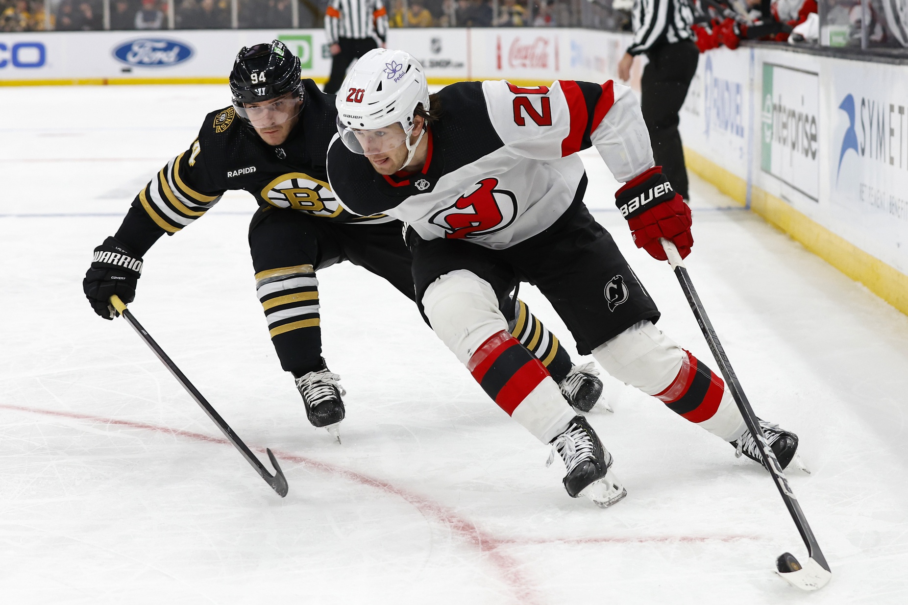 Jan 15, 2024; Boston, Massachusetts, USA; New Jersey Devils center Michael McLeod (20) tries to hold off Boston Bruins center Jakub Lauko (94) during the second period at TD Garden.
