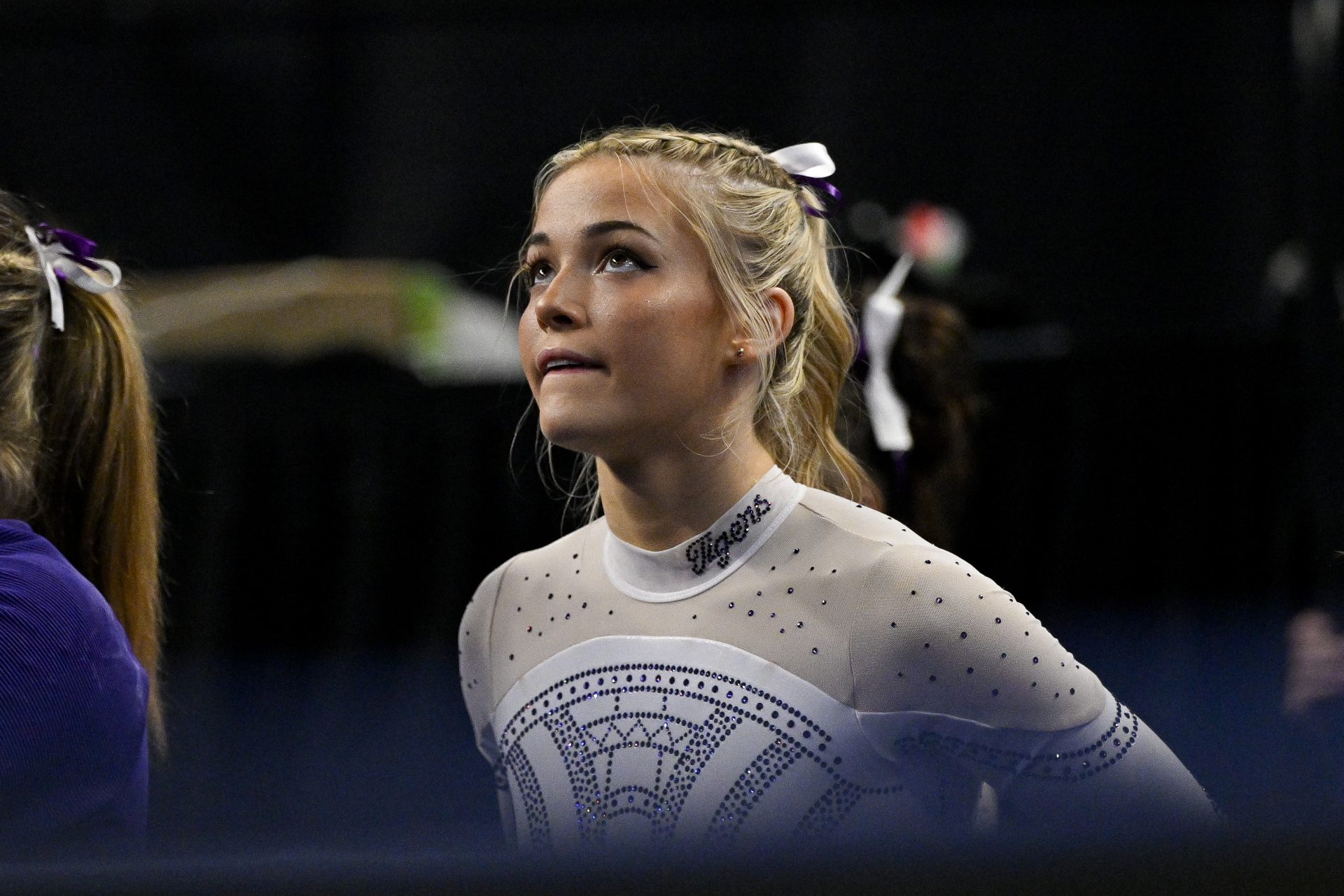 Apr 20, 2024; Fort Worth, TX, USA; LSU Tigers gymnast Olivia Dunne watches as LSU Tigers gymnast Haleigh Bryant performs on uneven bars during the 2024 Womens National Gymnastics Championship at Dickies Arena.
