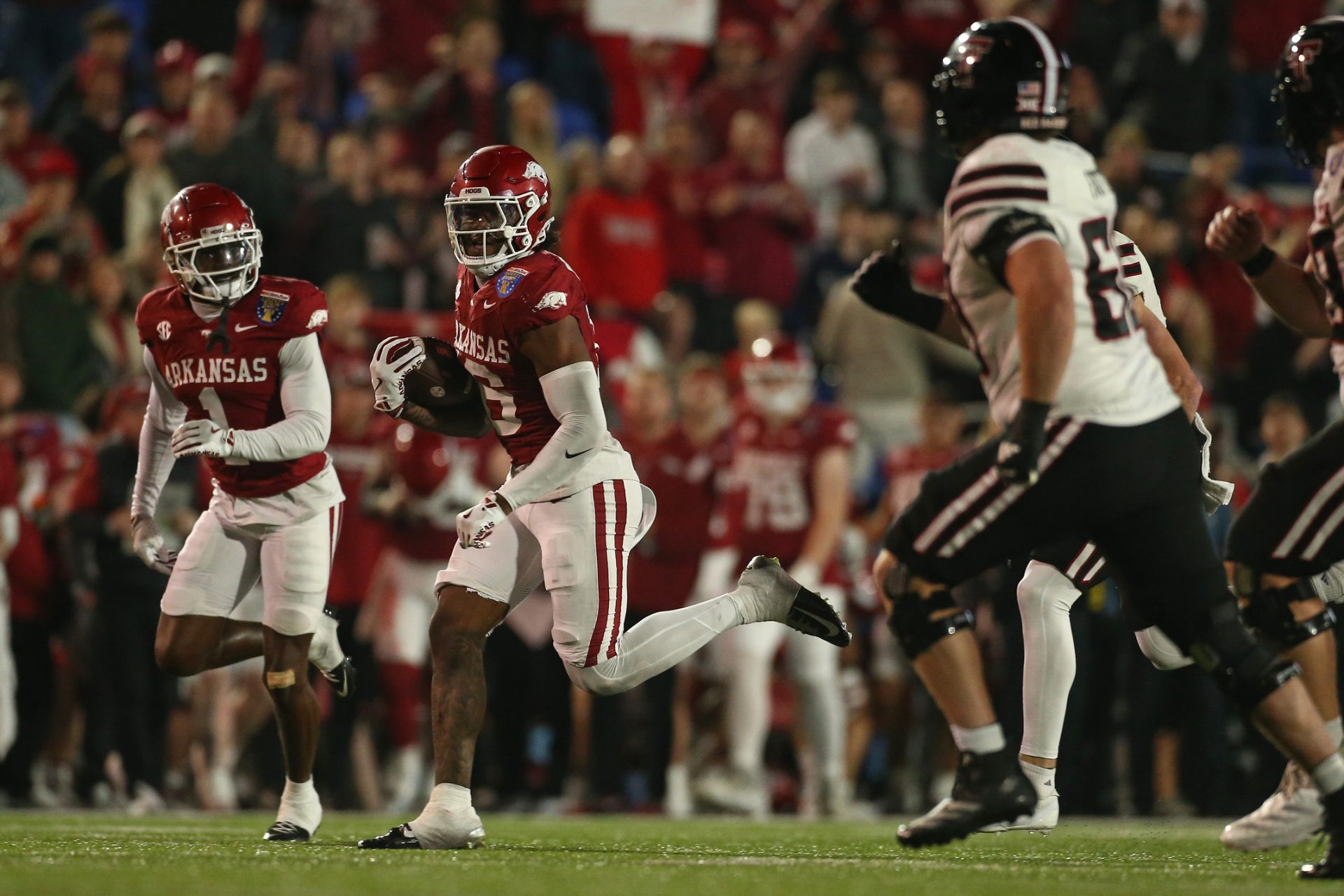 Dec 27, 2024; Memphis, TN, USA; Arkansas Razorbacks defensive back Miguel Mitchell (16) returns an interception during the forth quarter against the Texas Tech Red Raiders at Simmons Bank Liberty Stadium.