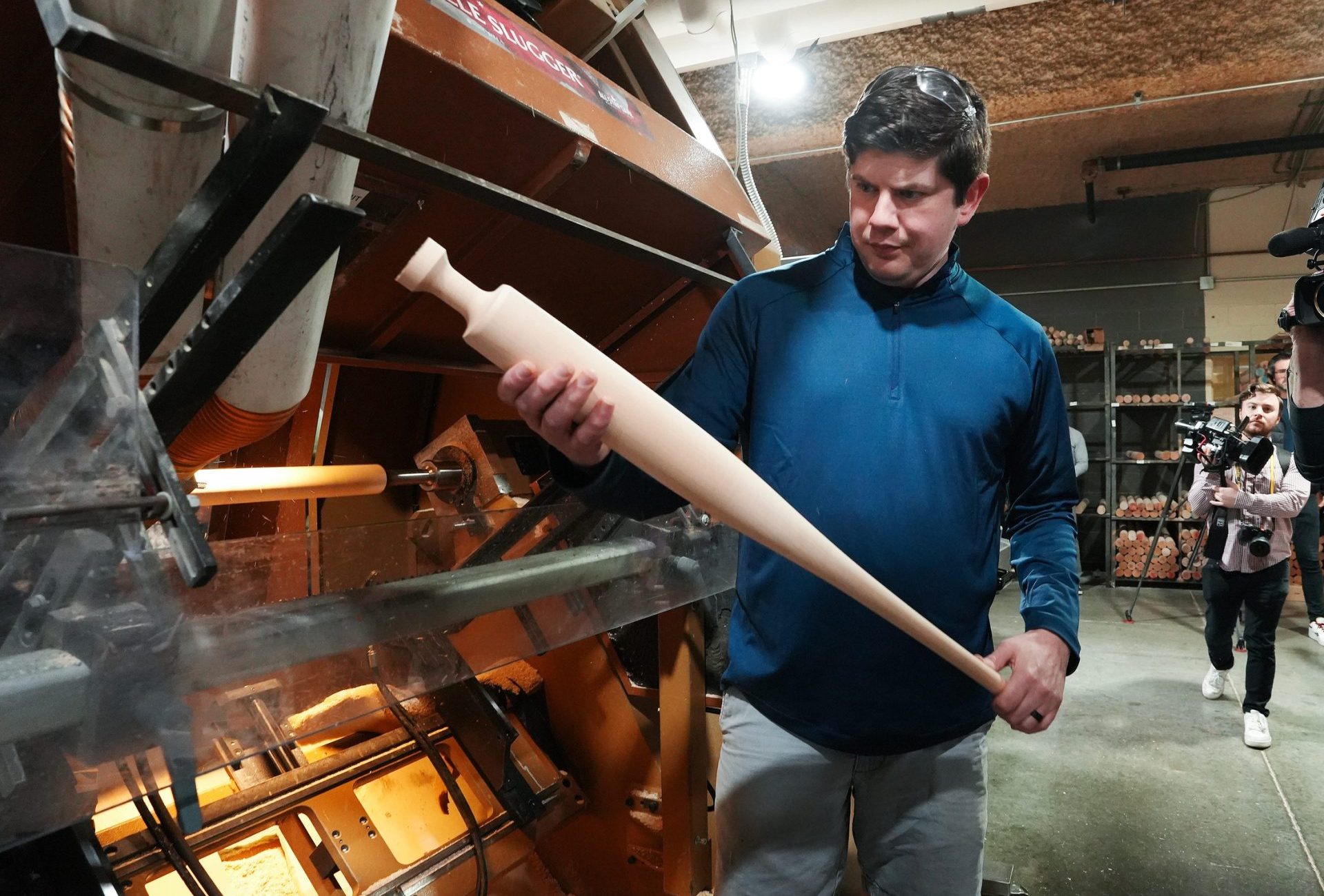 Kelly Coleman, pro bat lead operator, inspects a torpedo bat after it comes out of a baseball bat lathe at the Louisville Slugger Museum & Factory in Louisville, Ky. on Mar. 31, 2025.
