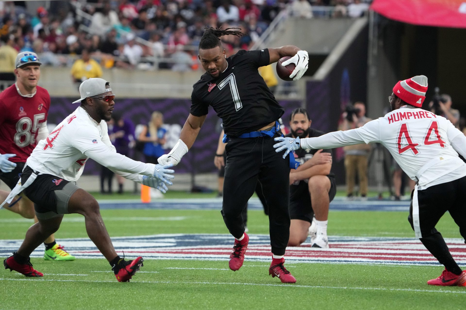 Feb 2, 2025; Orlando, FL, USA; NFC running back Bijan Robinson of the Atlanta Falcons (7) carries the ball against AFC linebacker Zaire Franklin of the Indianapolis Colts (left) and cornerback Marlon Humphrey of the Baltimore Ravens during the 2025 Pro Bowl Games at Camping World Stadium.