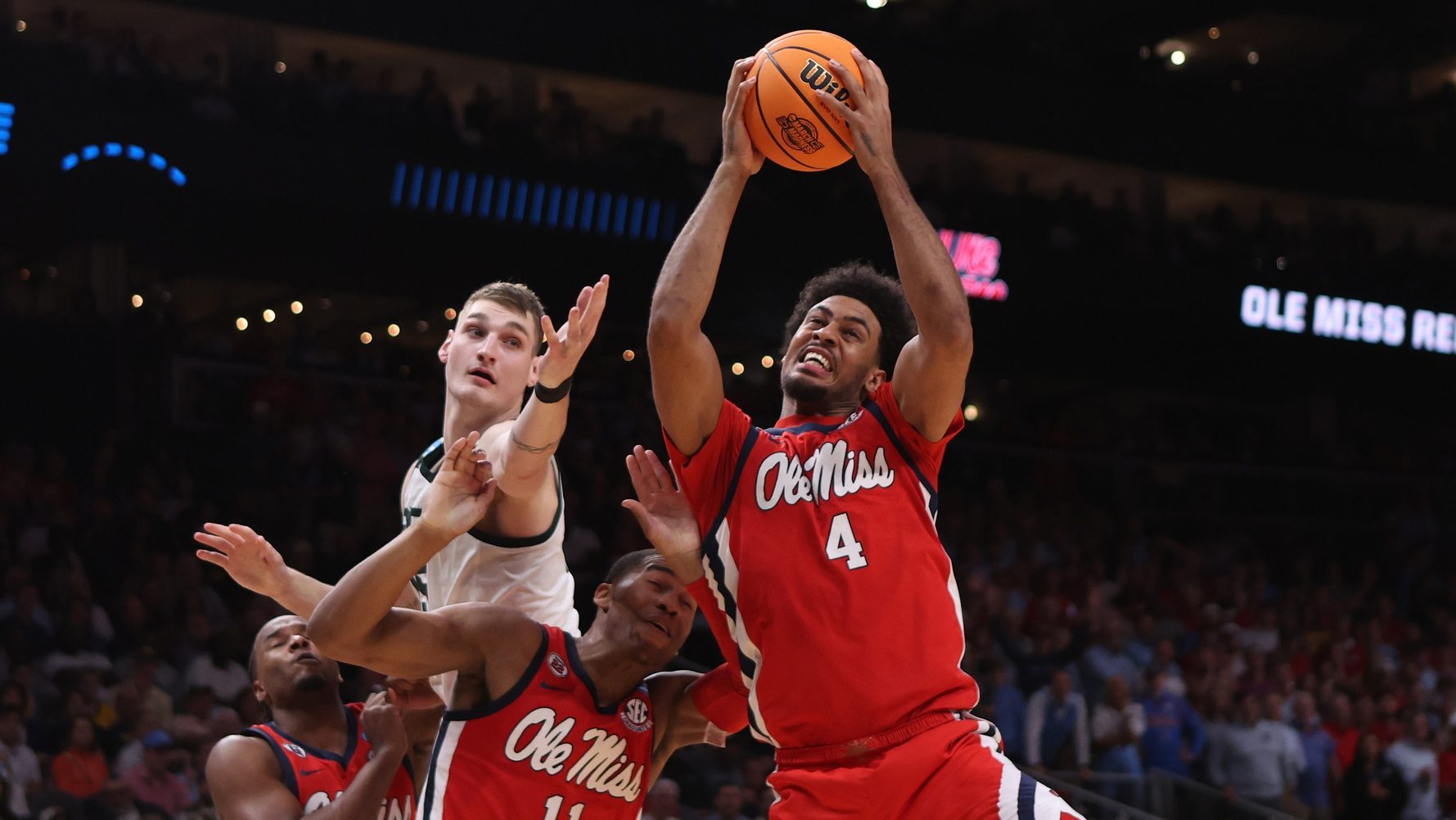 Mar 28, 2025; Atlanta, GA, USA; Mississippi Rebels forward Jaemyn Brakefield (4) rebounds over Michigan State Spartans center Carson Cooper (15) and Mississippi Rebels guard Matthew Murrell (11) in the second half of a South Regional semifinal of the 2025 NCAA tournament at State Farm Arena.