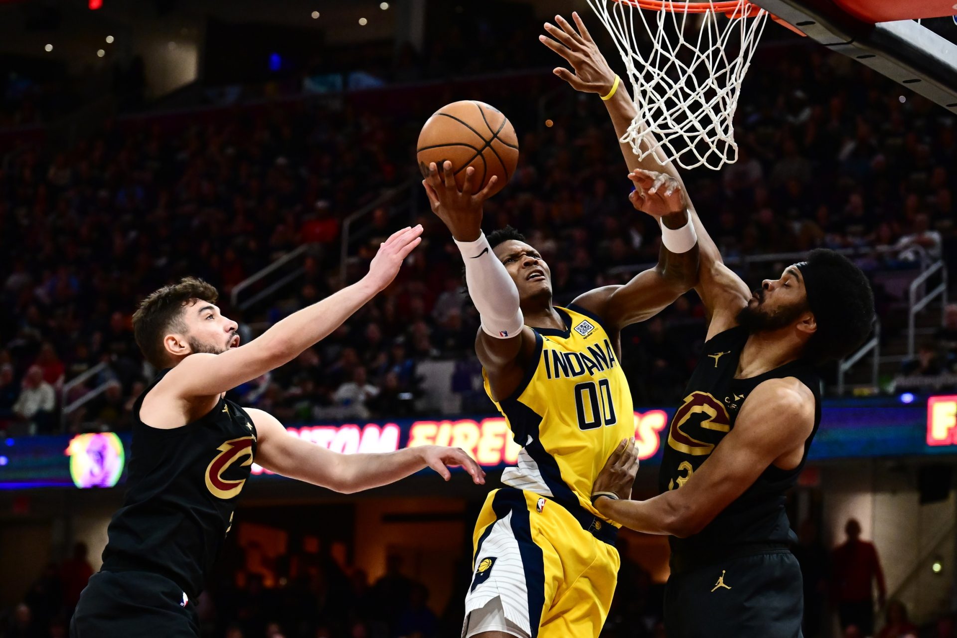 May 13, 2025; Cleveland, Ohio, USA; Indiana Pacers guard Bennedict Mathurin (00) drives to the basket between Cleveland Cavaliers guard Ty Jerome (2) and center Jarrett Allen (31) during the second half of game five of the second round for the 2025 NBA Playoffs at Rocket Arena.