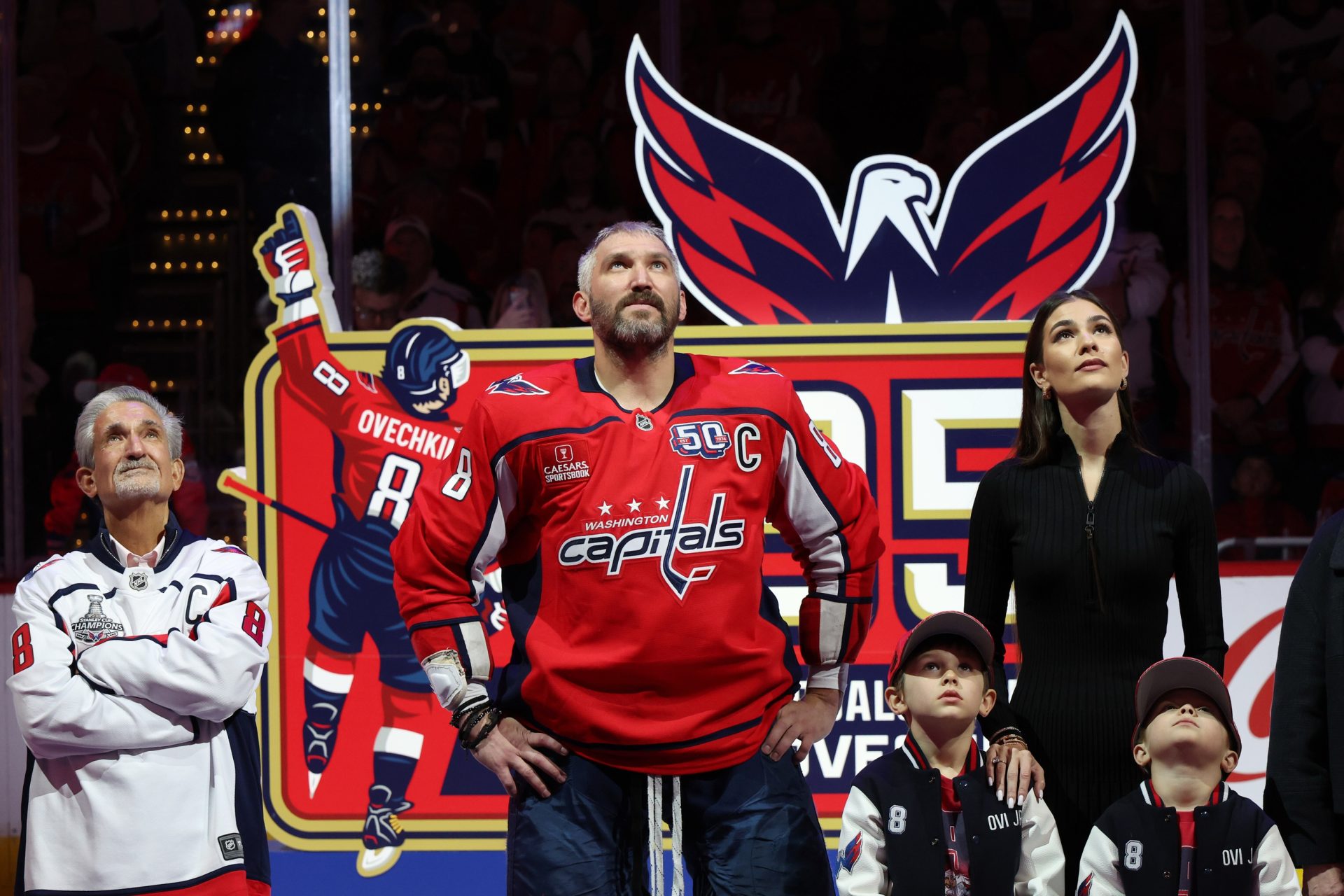 Apr 10, 2025; Washington, District of Columbia, USA; (L-R) Washington Capitals owner Ted Leonsis, Capitals left wing Alex Ovechkin (8), Ovechkin's wife Nastya, and sons Sergei and Ilya watch a video during a ceremony honoring Ovechkin's becoming the NHL all-time goals leader prior to the Capitals' game against the Carolina Hurricanes at Capital One Arena.