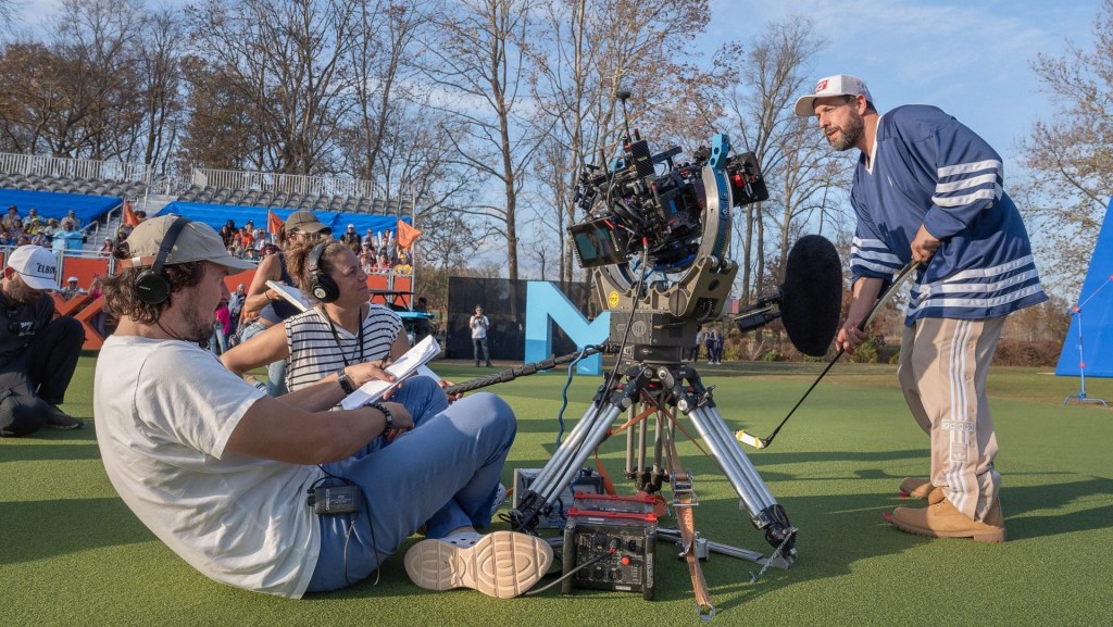 HAPPY GILMORE 2. - BTS - (L to R) Director Kyle Newacheck and Adam Sandler as Happy Gilmore (Writer/Producer) with crew members on the set of Happy Gilmore 2.