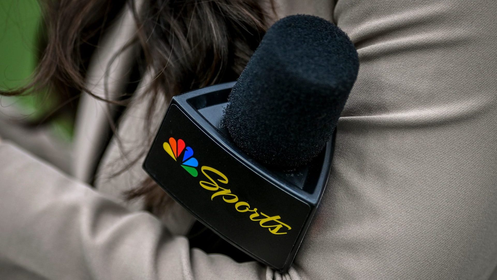 A Peacock sideline reporter holds a microphone with the NBC Peacock logo during Michigan State's football game against Washington on Saturday, Sept. 16, 2023, at Spartan Stadium in East Lansing.