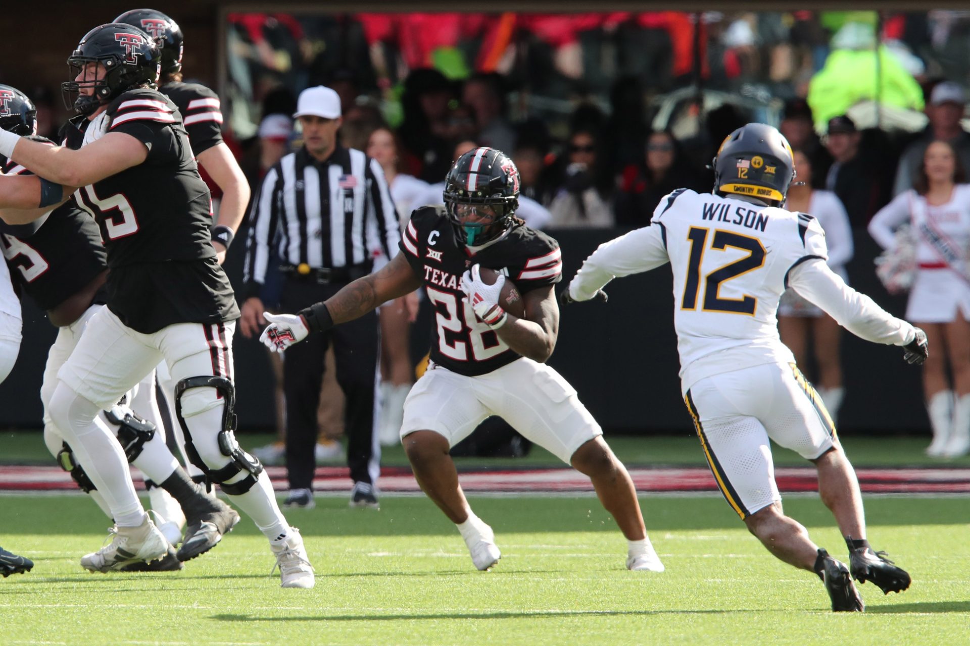 Nov 30, 2024; Lubbock, Texas, USA; Texas Tech Red Raiders running back Tahj Brooks (28) runs the ball against West Virginia Mountaineers defensive back Anthony Wilson Jr. (12) in the second half at Jones AT&T Stadium and Cody Campbell Field.