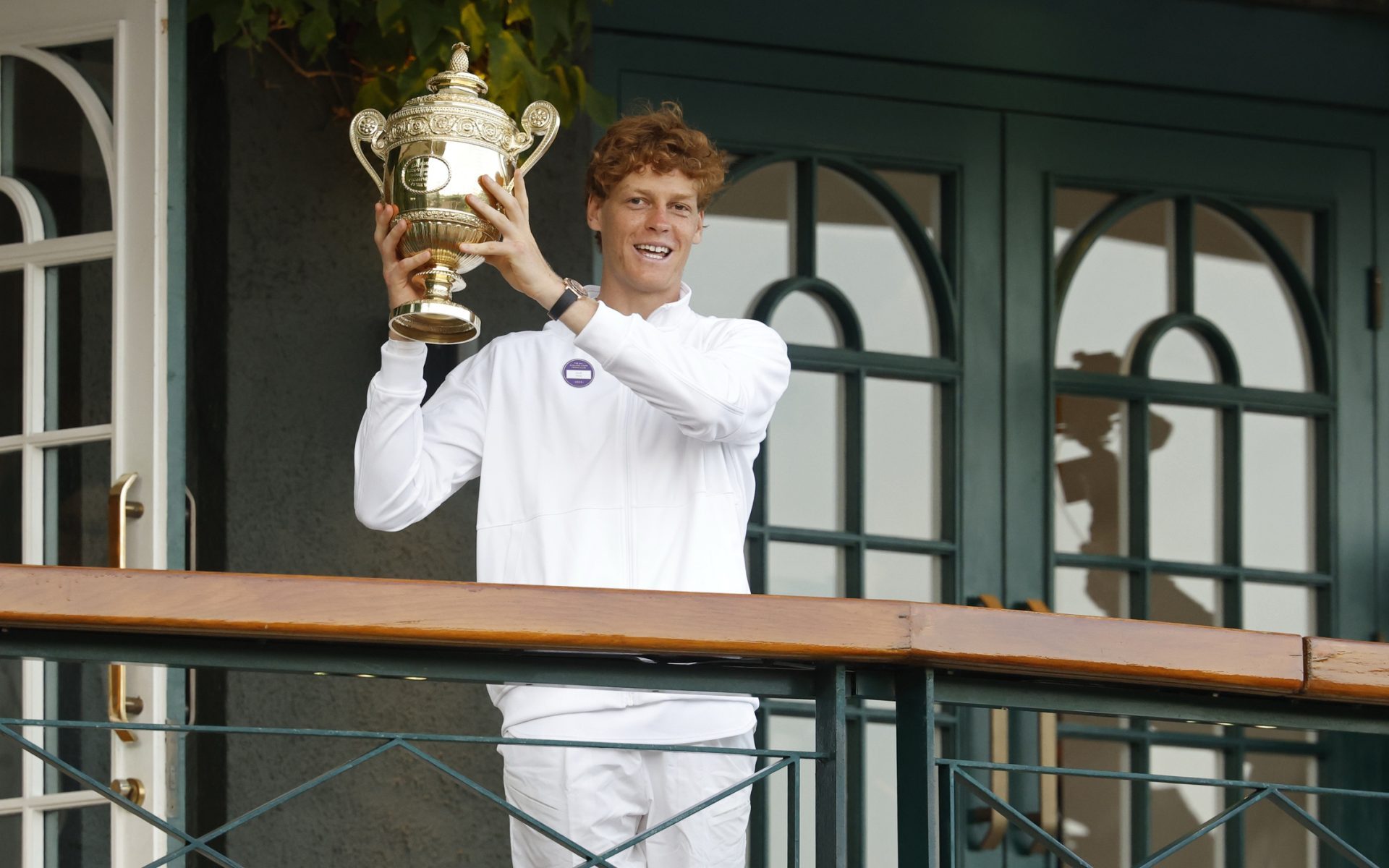 Jul 13, 2025; Wimbledon, United Kingdom; Jannik Sinner (ITA) stands on the South West Hall balcony holding the gentlemen's singles champion trophy, after his match against Carlos Alcaraz (ESP)(not pictured) in the gentlemen's' singles final of The Championships Wimbledon 2025 at All England Lawn Tennis and Croquet Club.