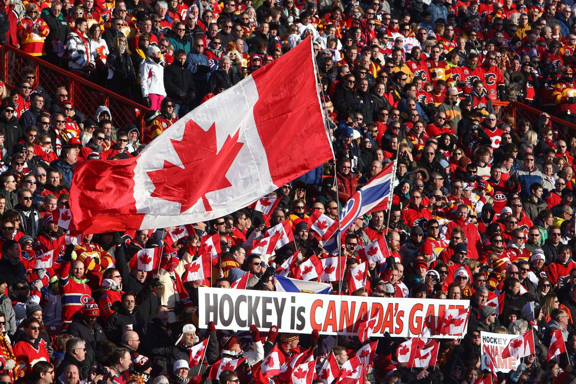 Feb 20, 2011; Calgary, AB, Canada; Canadian hockey fans wave a flag and display a banner before the Heritage Classic between the Montreal Canadiens and the Calgary Flames at McMahon Stadium. The Flames beat the Canadiens 4-0