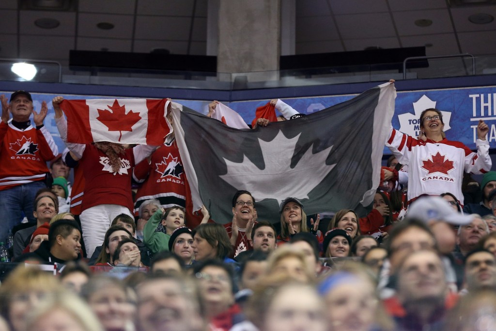 Dec 30, 2013; Toronto, Ontario, Canada; Canada fans wave Canadian flags against USA during the first period in an exhibition hockey game at Air Canada Centre. USA beat Canada 3-2