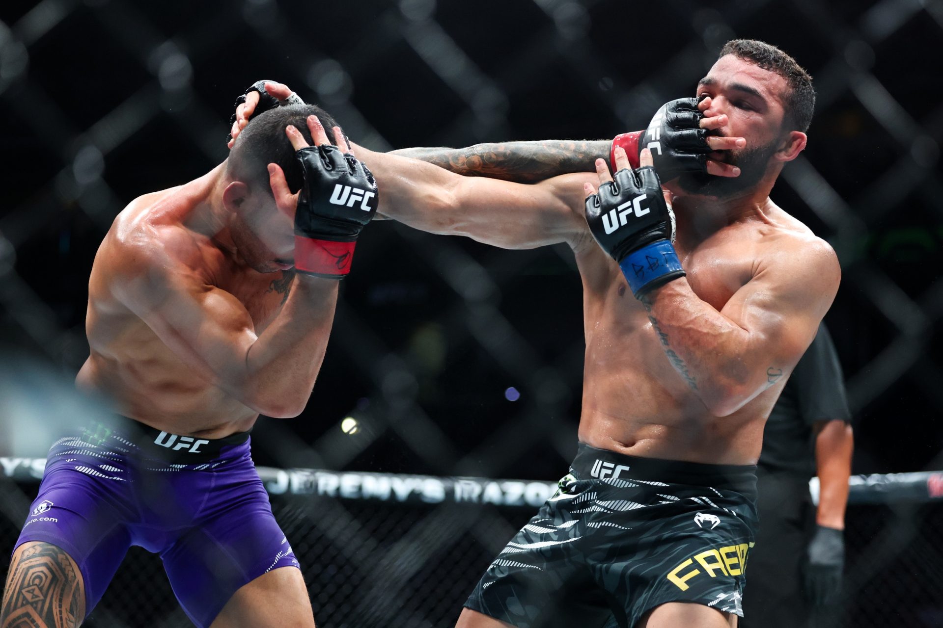 Jul 19, 2025; New Orleans, Louisiana, UNITED STATES; Dan Ige (red gloves) fights against Patricio Pitbull (blue gloves) during UFC 318 at Smoothie King Center.