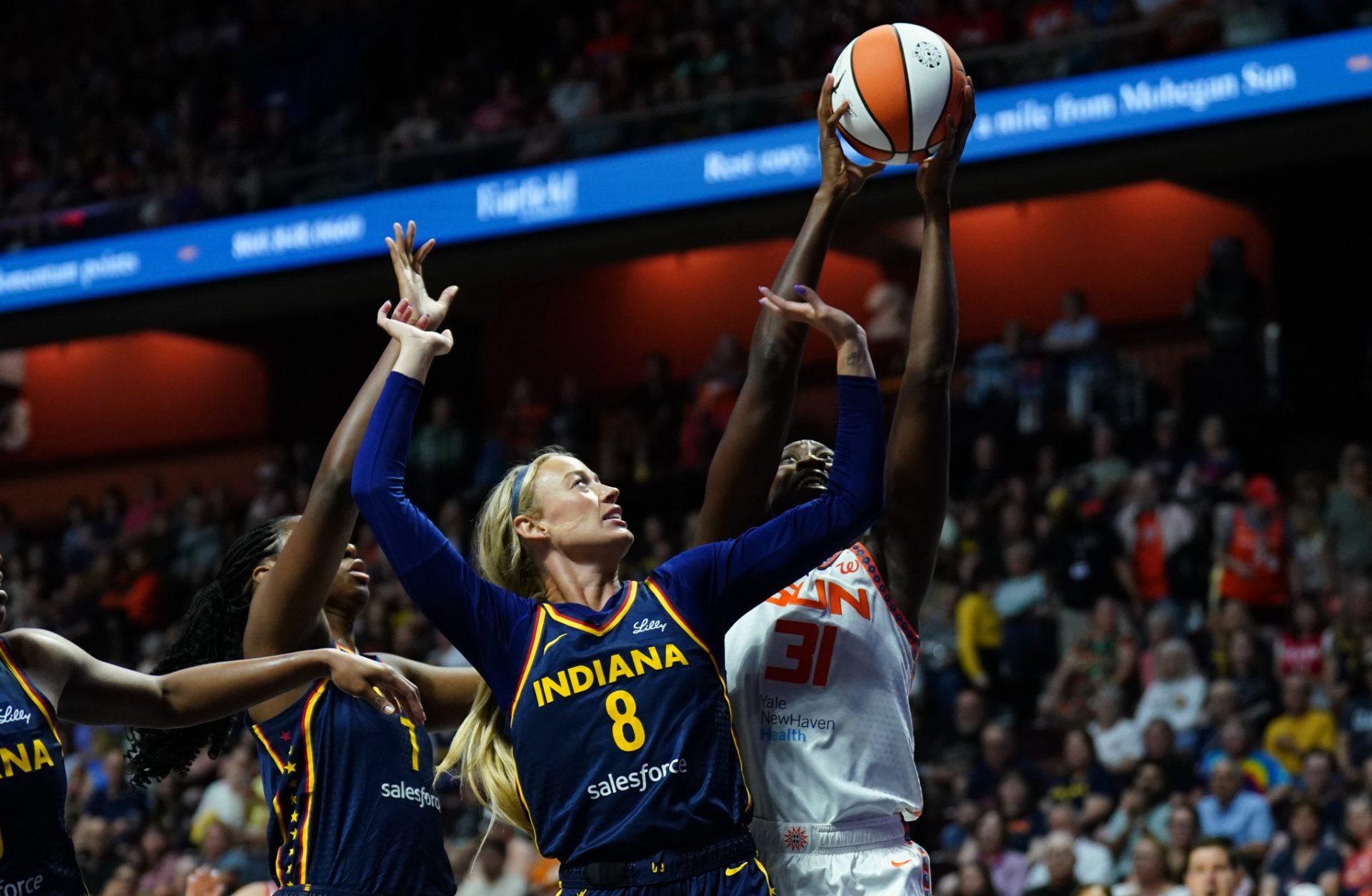 Aug 17, 2025; Uncasville, Connecticut, USA; Connecticut Sun center Tina Charles (31) and Indiana Fever guard Sophie Cunningham (8) work for the ball in the first half at Mohegan Sun Arena.
