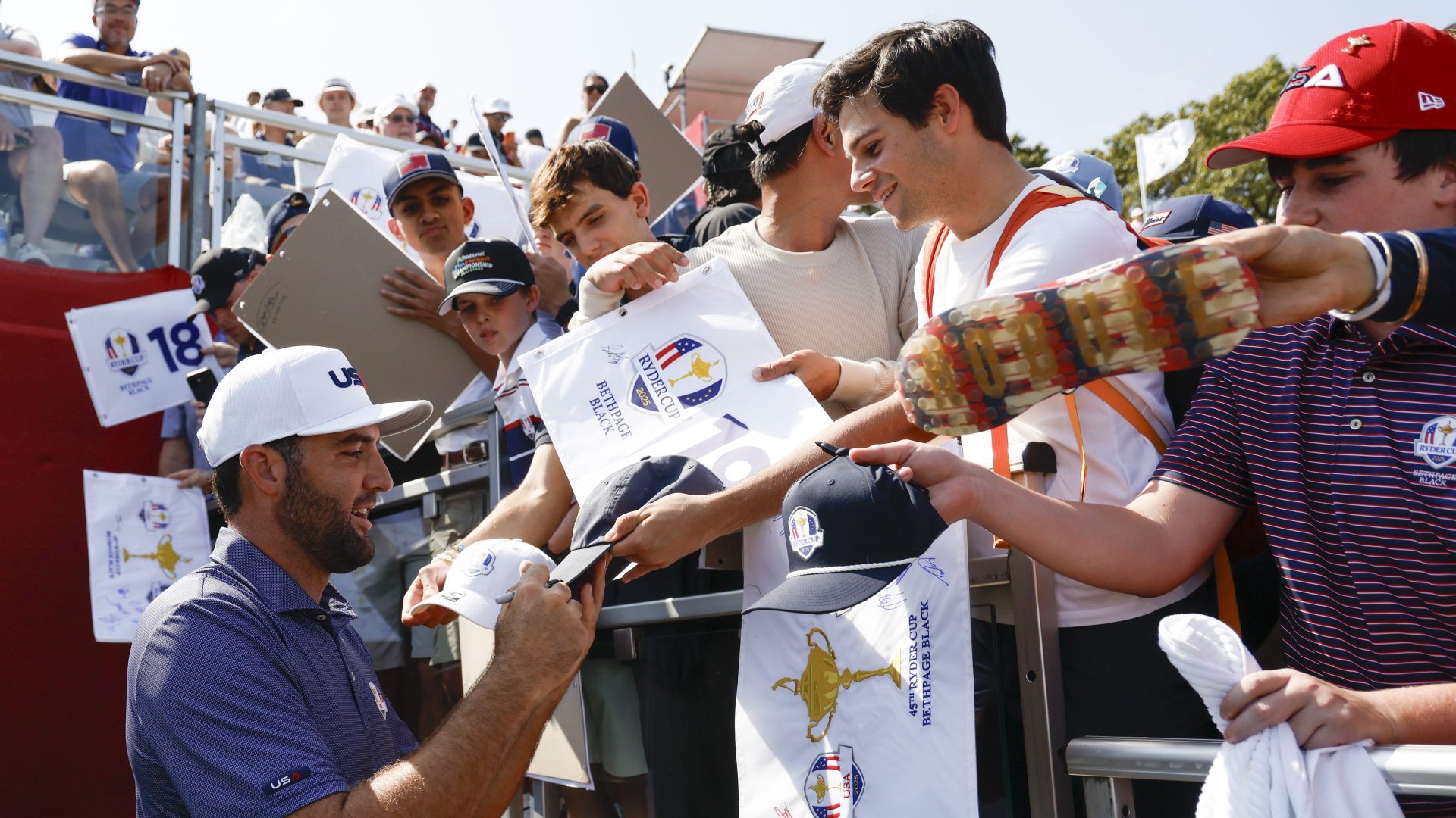 FARMINGDALE, NY - SEPTEMBER 23: Scottie Scheffler of Team United States signs autographs on the 18th hole during the 2025 Ryder Cup at Bethpage State Park on Tuesday, September 23, 2025 in Farmingdale, New York.