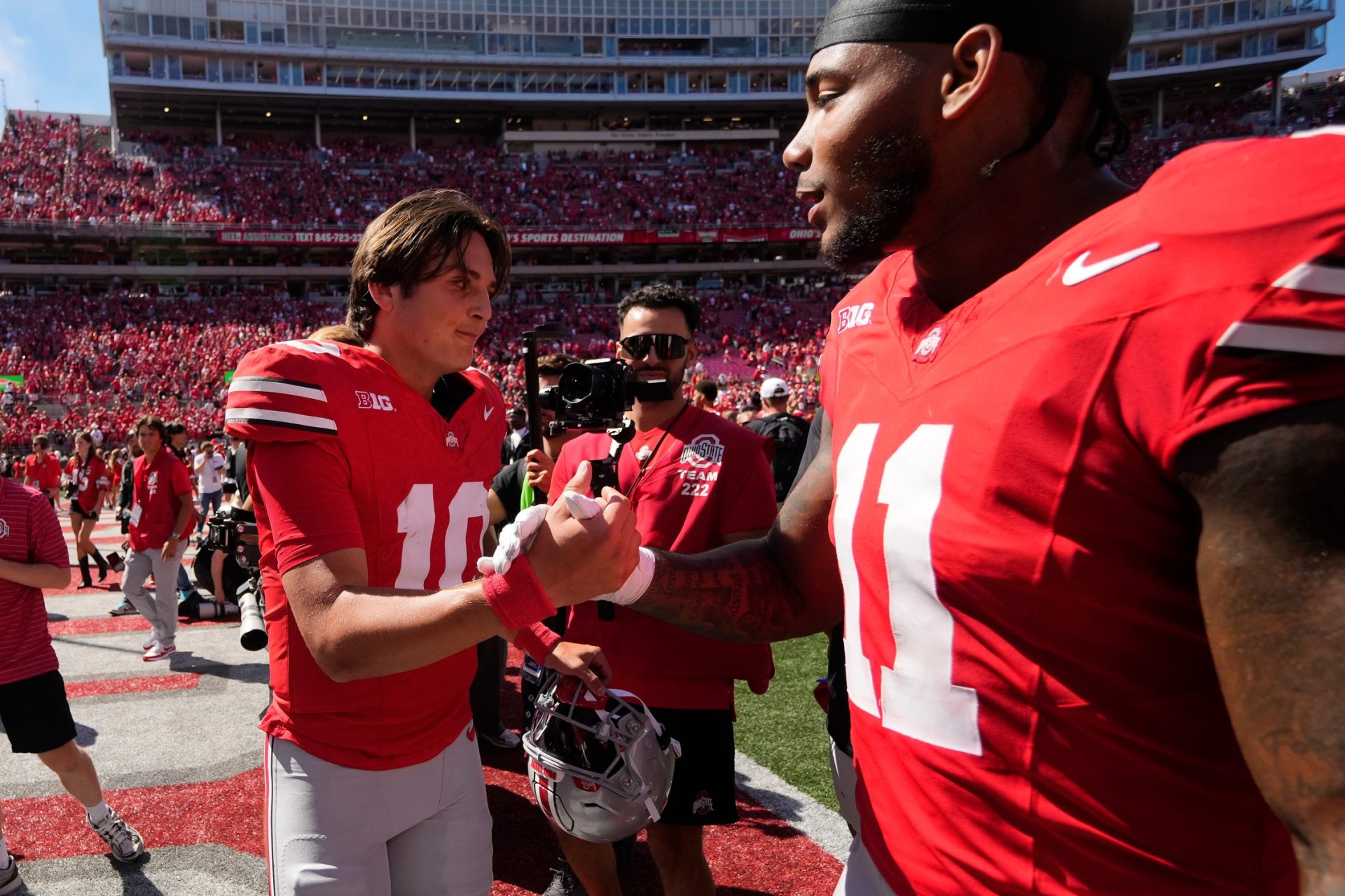 Ohio State Buckeyes quarterback Julian Sayin (10) and linebacker C.J. Hicks (11) shake hands while leaving the field following the NCAA football game at Ohio Stadium on Aug. 30, 2025. Ohio State won 14-7