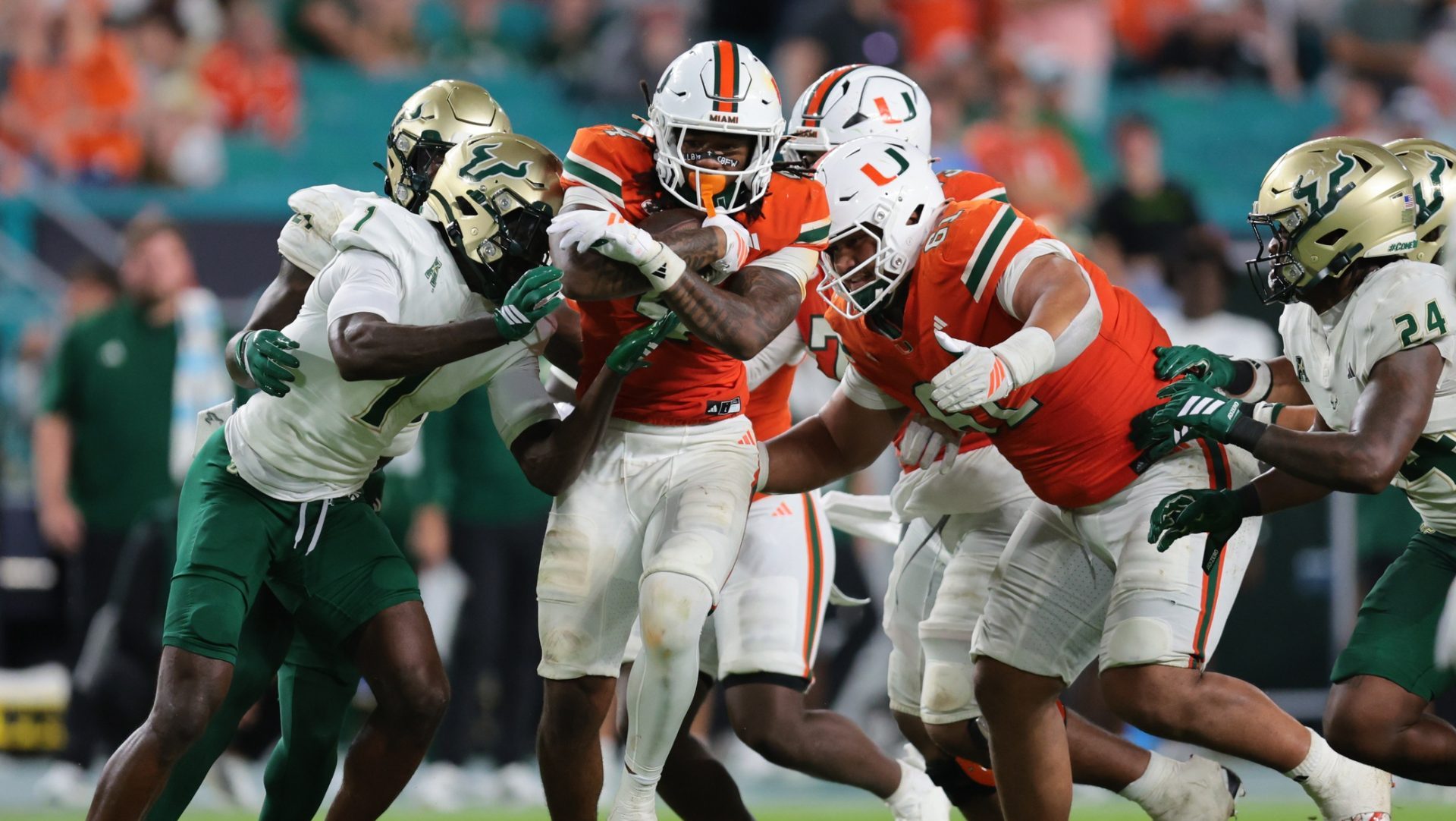 Sep 13, 2025; Miami Gardens, Florida, USA; Miami Hurricanes running back Mark Fletcher Jr. (4) carries the football against South Florida Bulls cornerback Ben Knox (1) during the third quarter at Hard Rock Stadium.