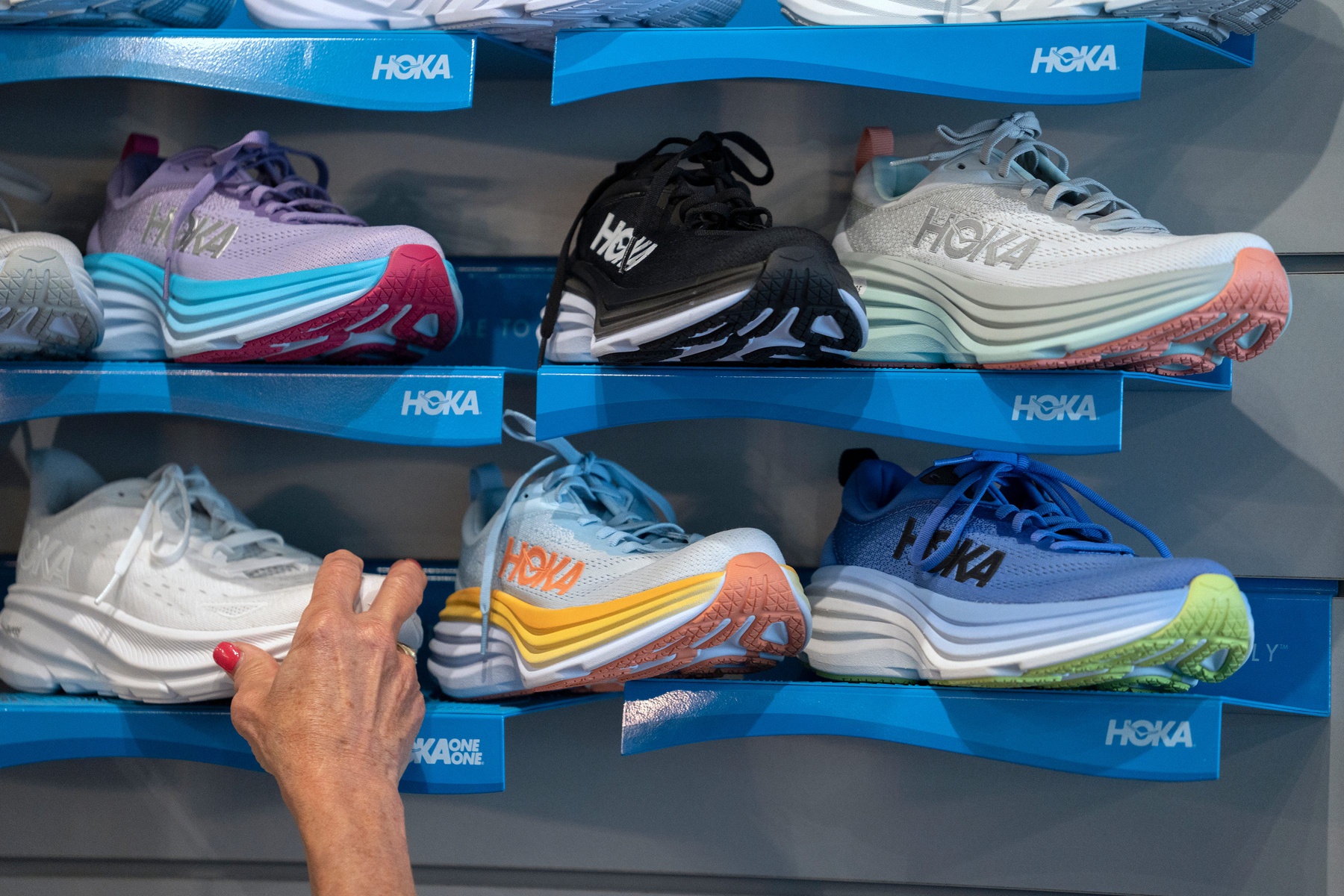 Patty Goodman straightens a display of Hoka shoes Friday, Aug. 30, 2024 at Goodman’s Shoes.