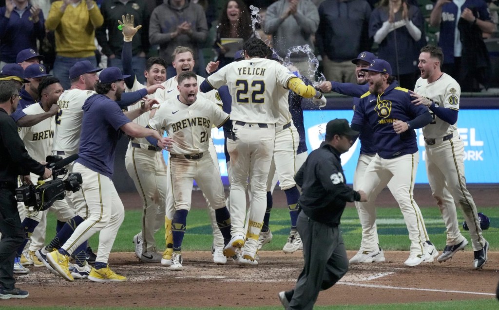 Milwaukee Brewers outfielder Christian Yelich (22) is swarmed by his teammates after hitting a walk-off grand slam home run during the tenth inning of their game against the Boston Red Sox Tuesday, May 27, 2025 at American Family Field in Milwaukee, Wisconsin. The Brewers beat the Red Sox 5-1 in 10 innings.