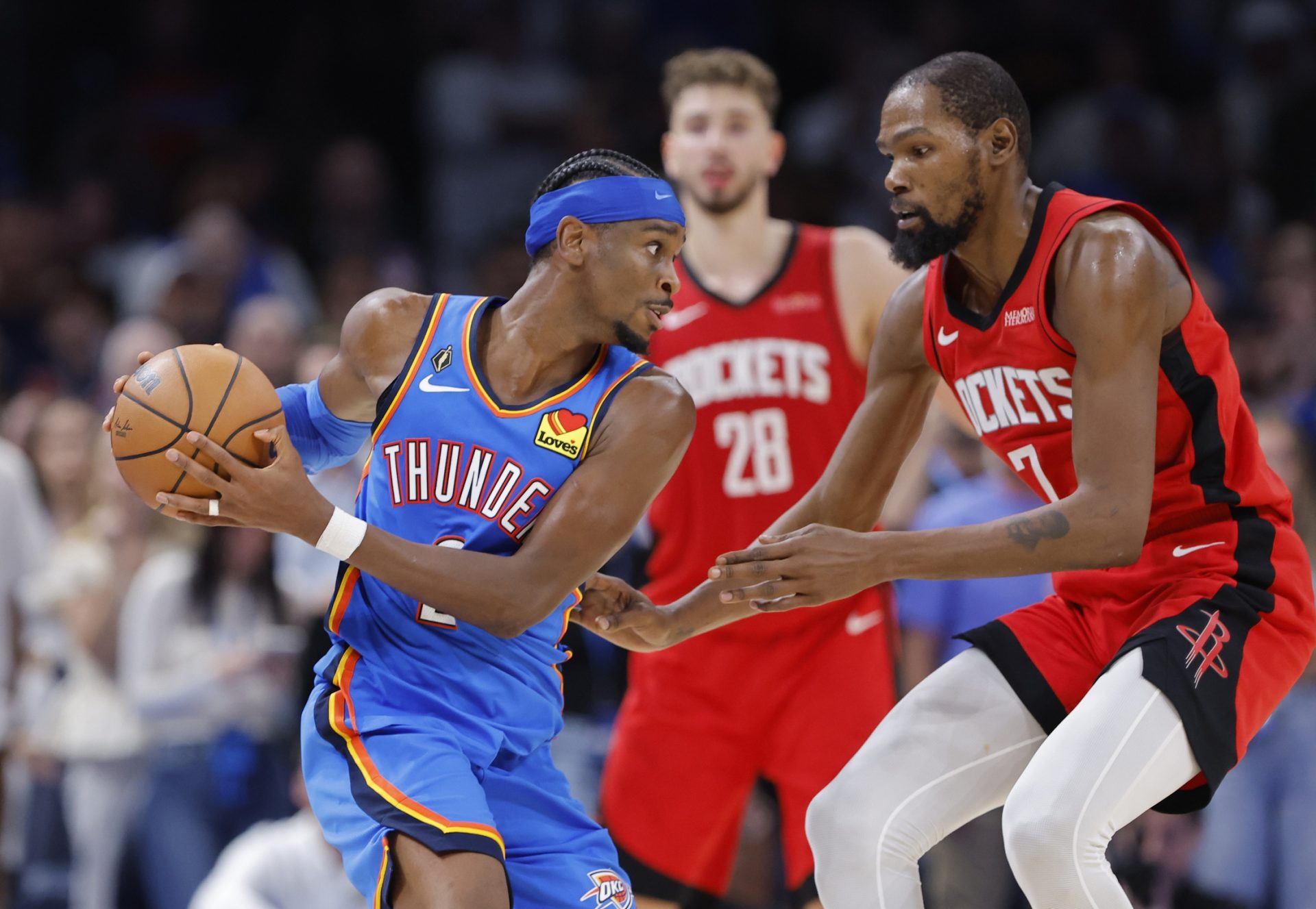 Oct 21, 2025; Oklahoma City, Oklahoma, USA; Oklahoma City Thunder guard Shai Gilgeous-Alexander (2) keeps the ball away from Houston Rockets forward Kevin Durant (7) during the second half at Paycom Center