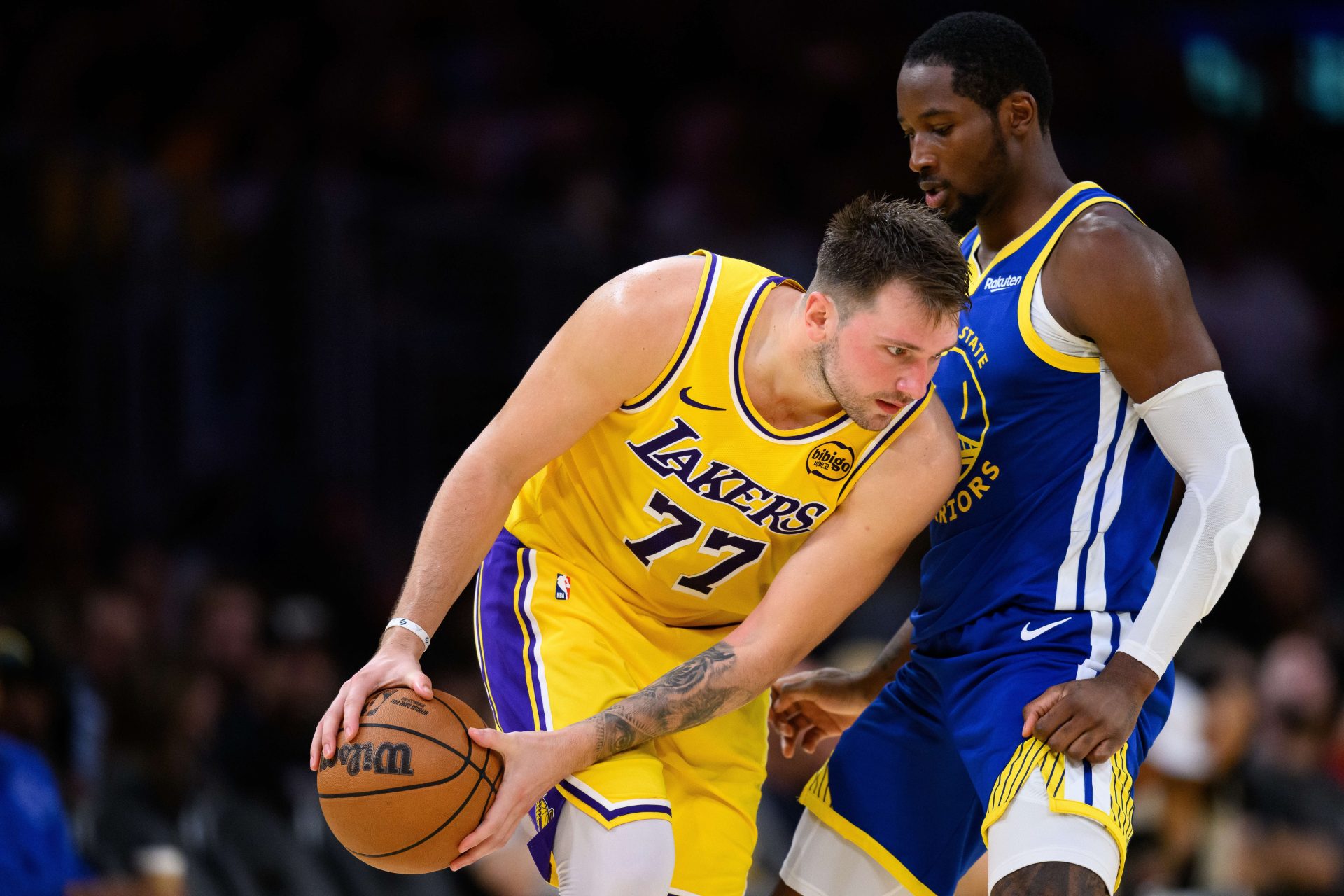 Oct 21, 2025; Los Angeles, California, USA; Los Angeles Lakers guard Luka Doncic (77) looks to drive against Golden State Warriors forward Jonathan Kuminga (1) during the second half at Crypto.com Arena.