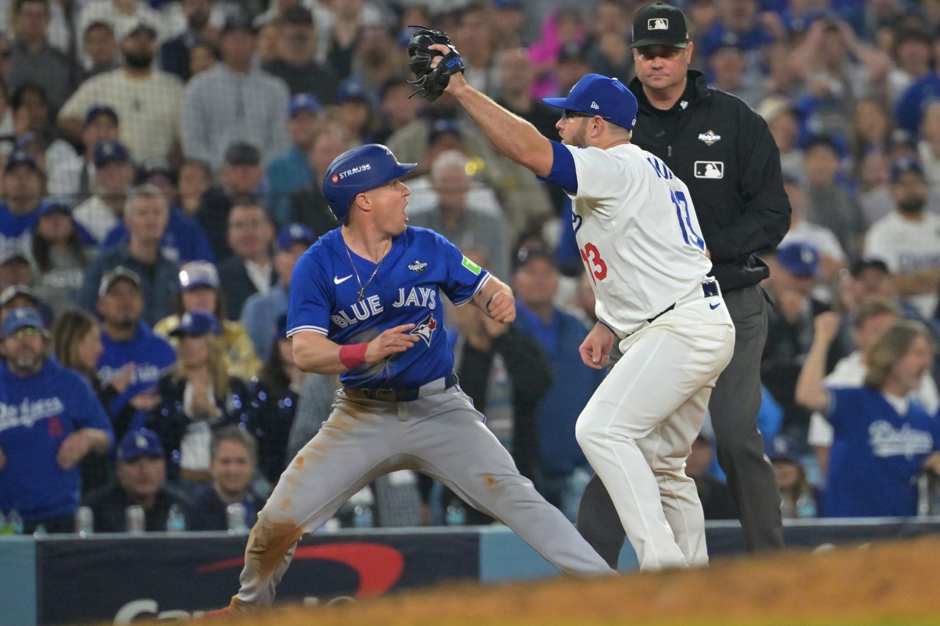 Oct 27, 2025; Los Angeles, California, USA; Toronto Blue Jays catcher Tyler Heineman (55) is safe at third base after the play is reviewed against Los Angeles Dodgers third baseman Max Muncy (13) in the twelfth inning during game three of the 2025 MLB World Series at Dodger Stadium.