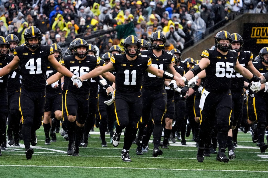 The Iowa Hawkeyes swarm onto the field Nov. 8, 2025 ahead of a Big Ten Football game against the Oregon Ducks at Kinnick Stadium in Iowa City, Iowa.
