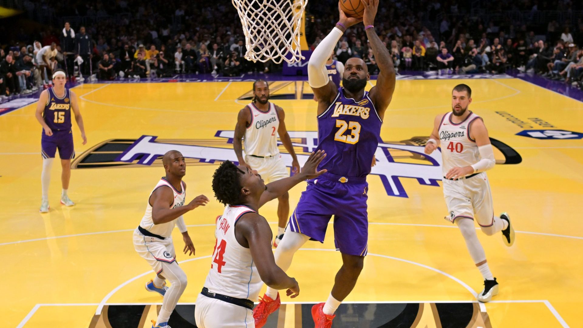 Nov 25, 2025; Los Angeles, California, USA; Los Angeles Lakers forward LeBron James (23) gets past Los Angeles Clippers guard Chris Paul (3), forward Kawhi Leonard (2), center Ivica Zubac (40) and guard Kobe Brown (24) for a basket in the second half at Crypto.com Arena.