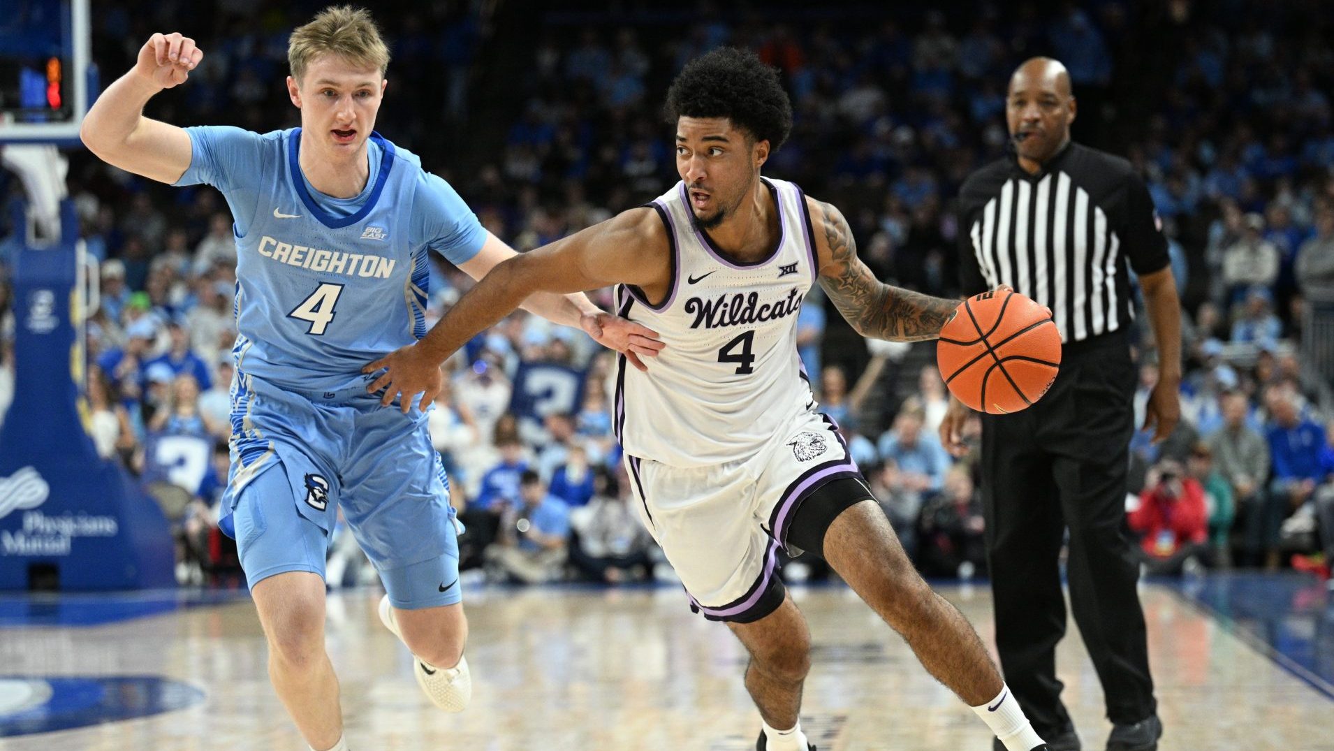 Dec 13, 2025; Omaha, Nebraska, USA; Kansas State Wildcats guard PJ Haggerty (4) drives around Creighton Bluejays guard Josh Dix (4) during the first half at CHI Health Center Omaha.